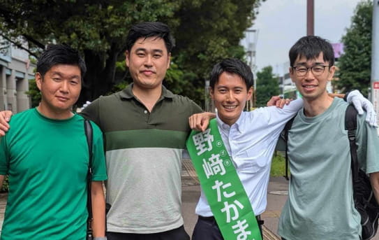 男性4人が肩を組んだ写真